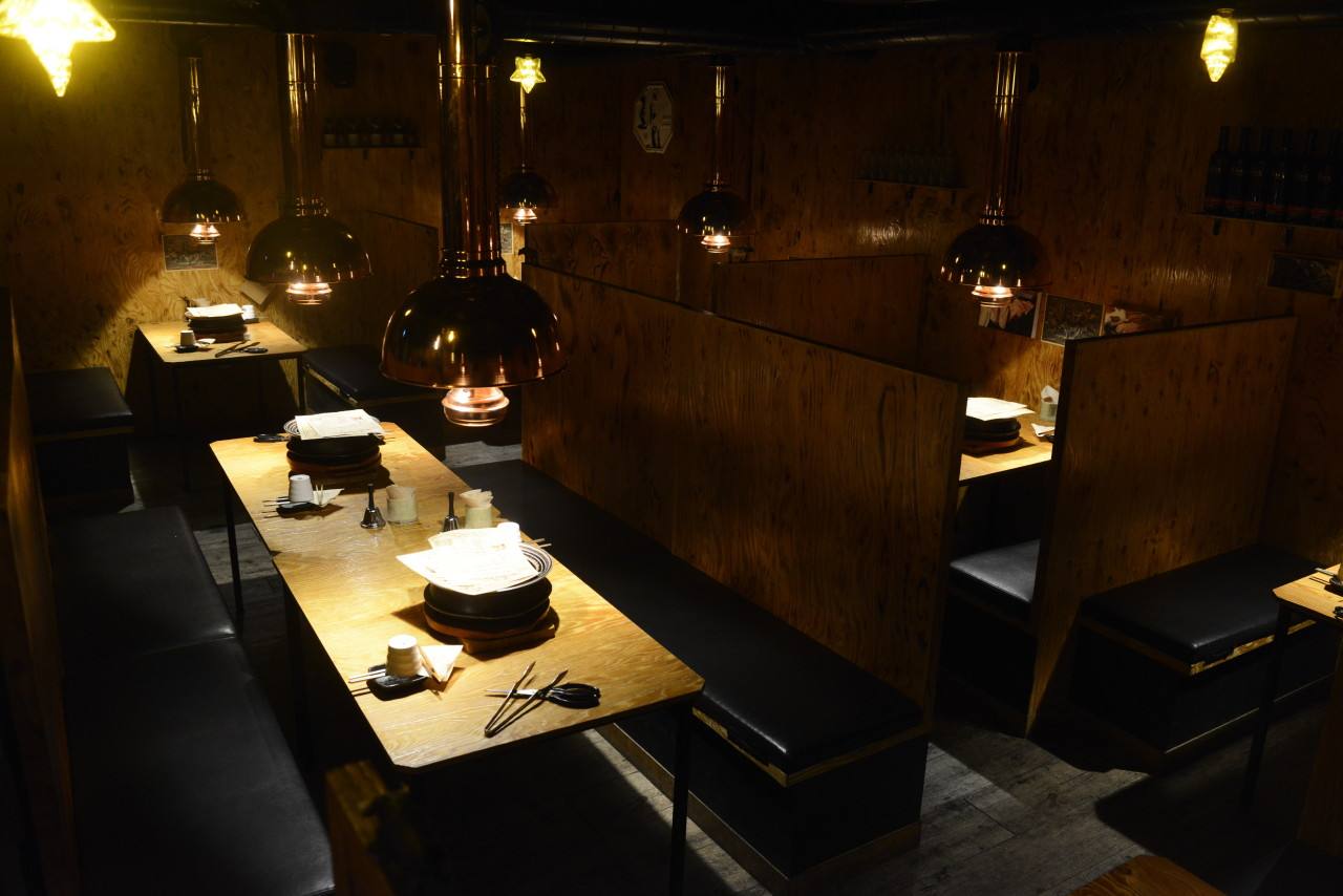 Warm timber-and-copper interior of ilpyeon Sirloin Hongdae